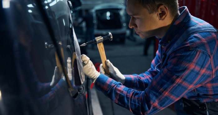Scratch removal on car door using paintless dent repair technique.